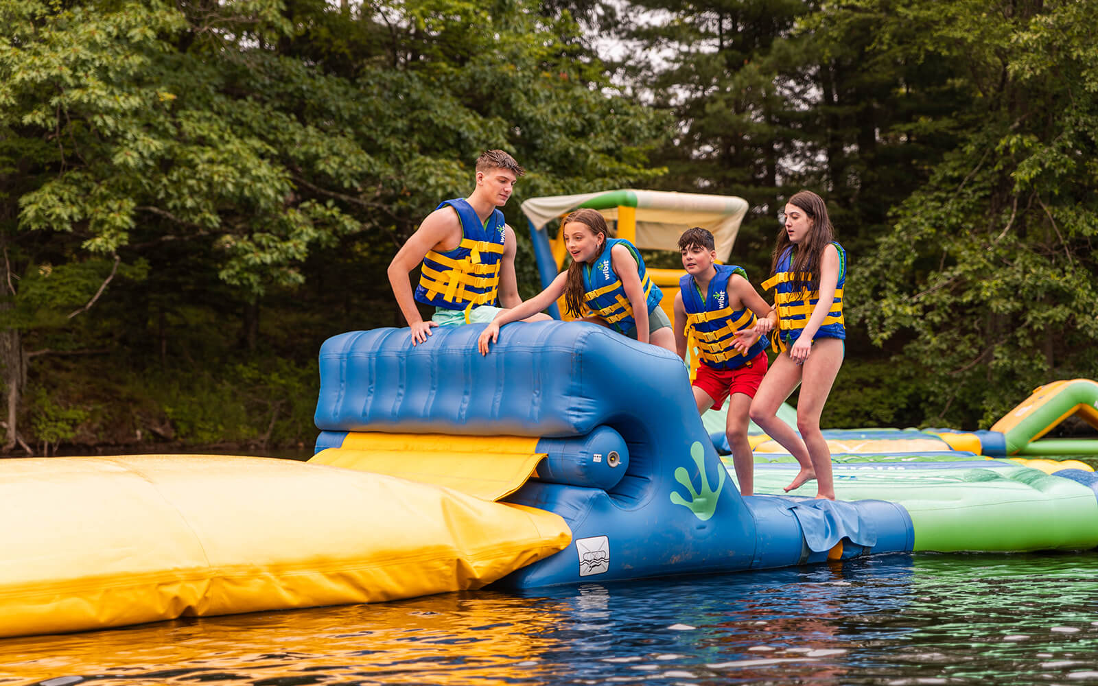 Kids playing on a blow up toy on the lake