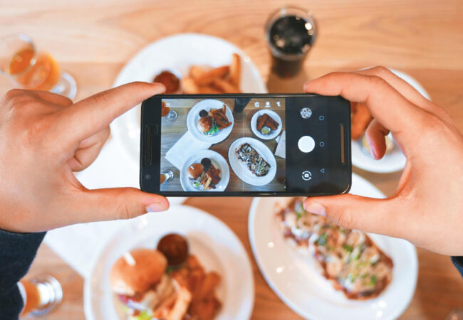 Person taking a picture of food with their phone