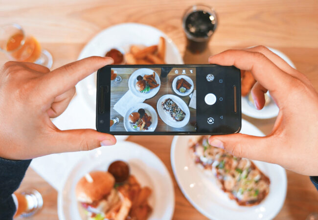 Person taking a picture of food with their phone