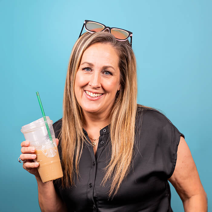 Headshot of a women in a black dress holding a cup of coffee | Amy Resch