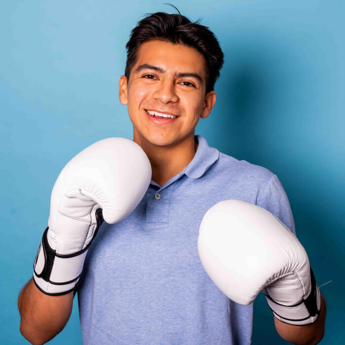 Headshot of a man in a blue shirt wearing boxing gloves | Jorge Ruiz