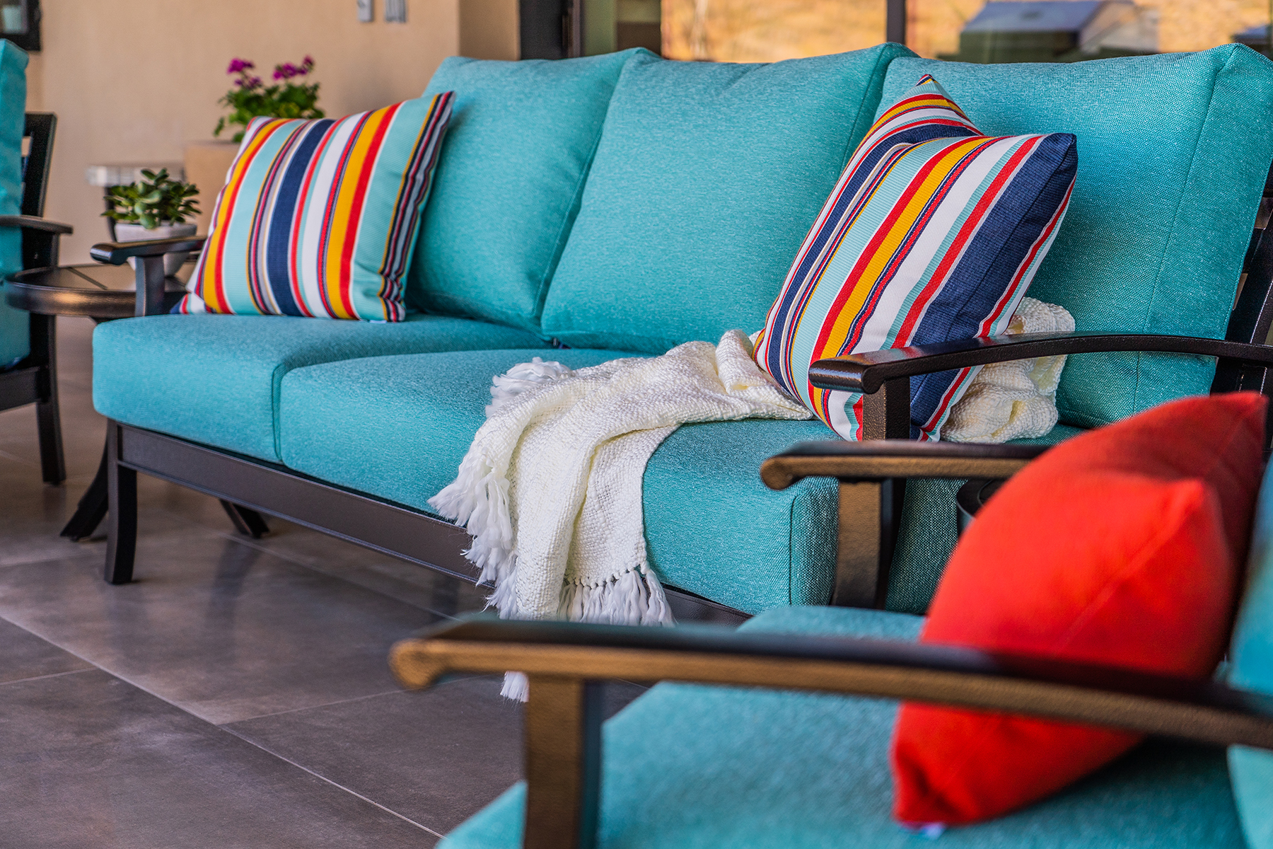 A blue outdoor couch with colorful pillows