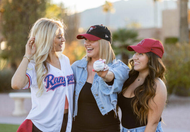 Group of three women dressed for a baseball gane