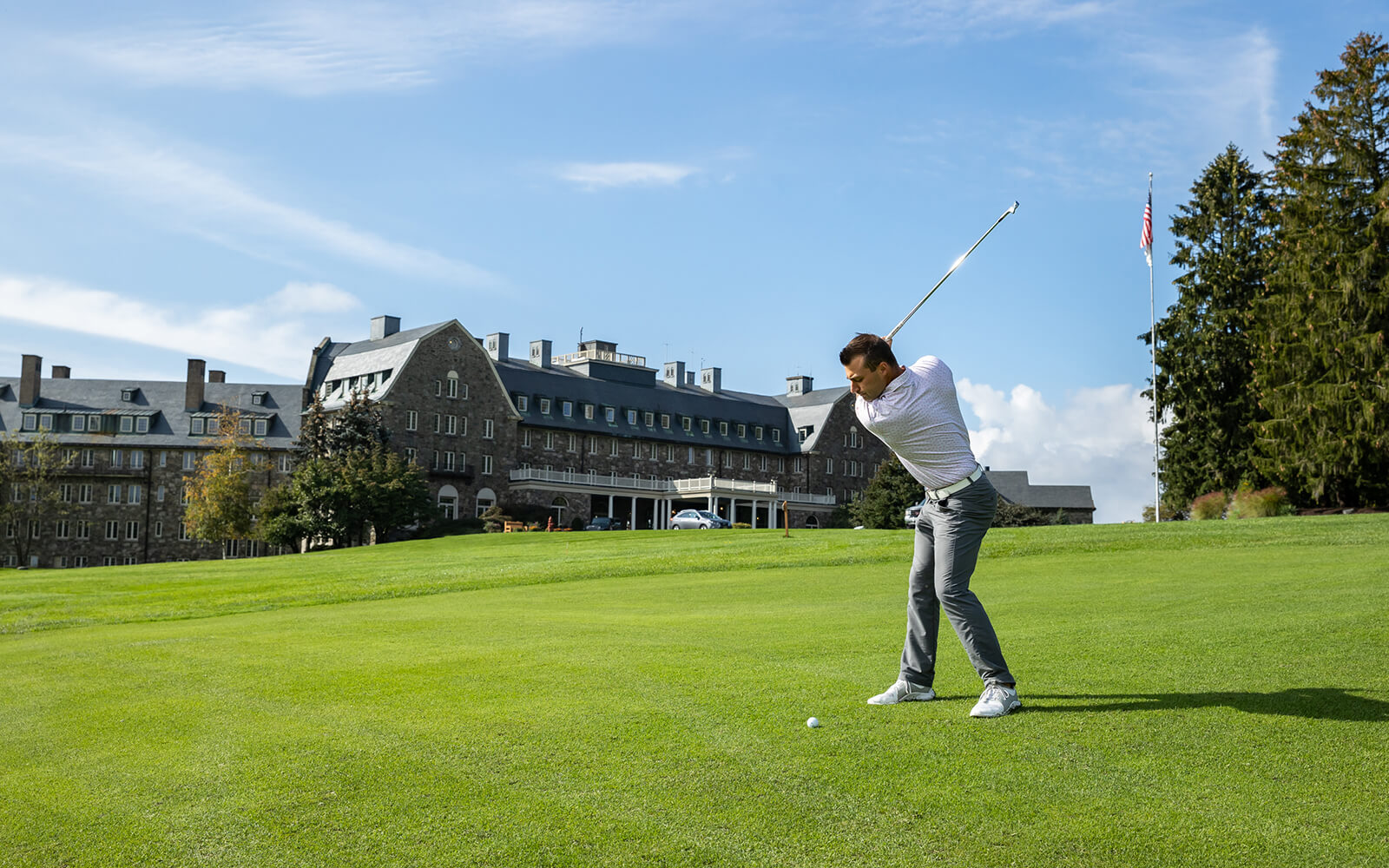 A man golfing outside of Skytop lodge