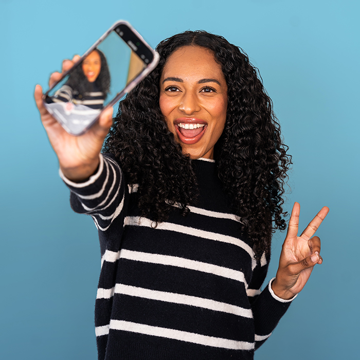 Headshot of a women in a black and white sweater taking a selfie | Alexis Bennett