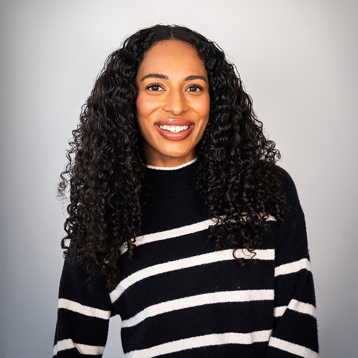 Headshot of a women in a black and white sweater | Alexis Bennett