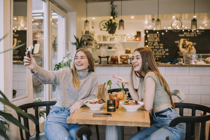 Teenager influencers trying food at vegan cafe