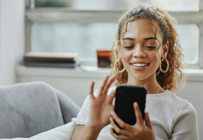 Black woman with smartphone on a sofa for networking online, mobile app or relax chat with home wifi. Young person on couch using phone for internet, social media post or email communication update