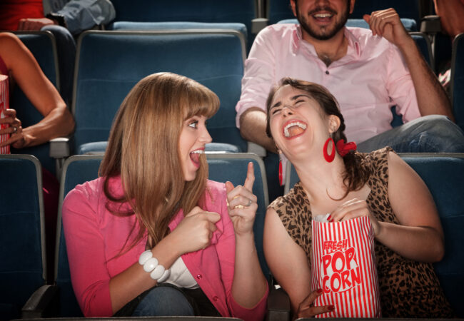 Women laughing in a movie theater