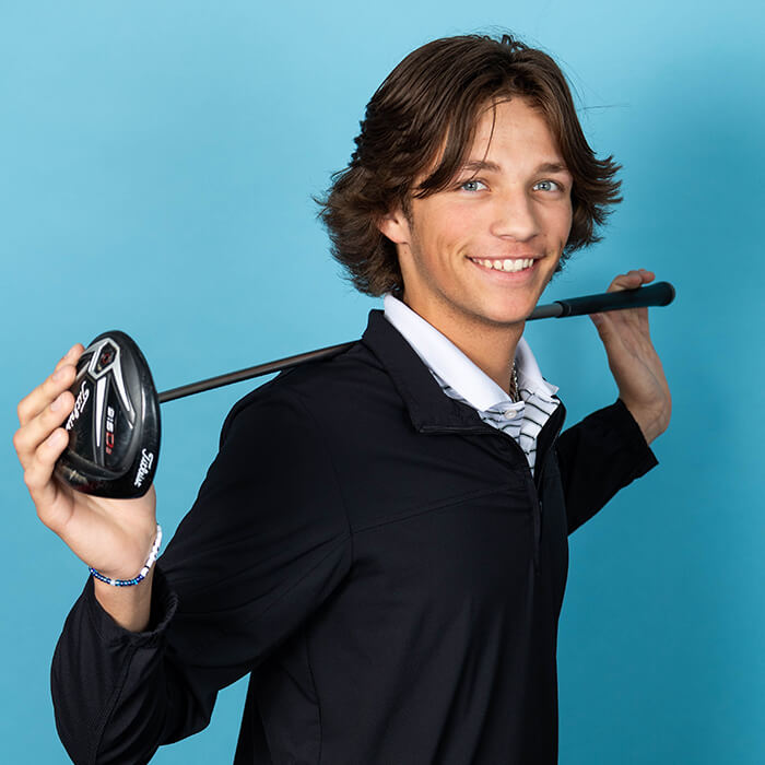 Headshot of man in black shirt holding a golf club