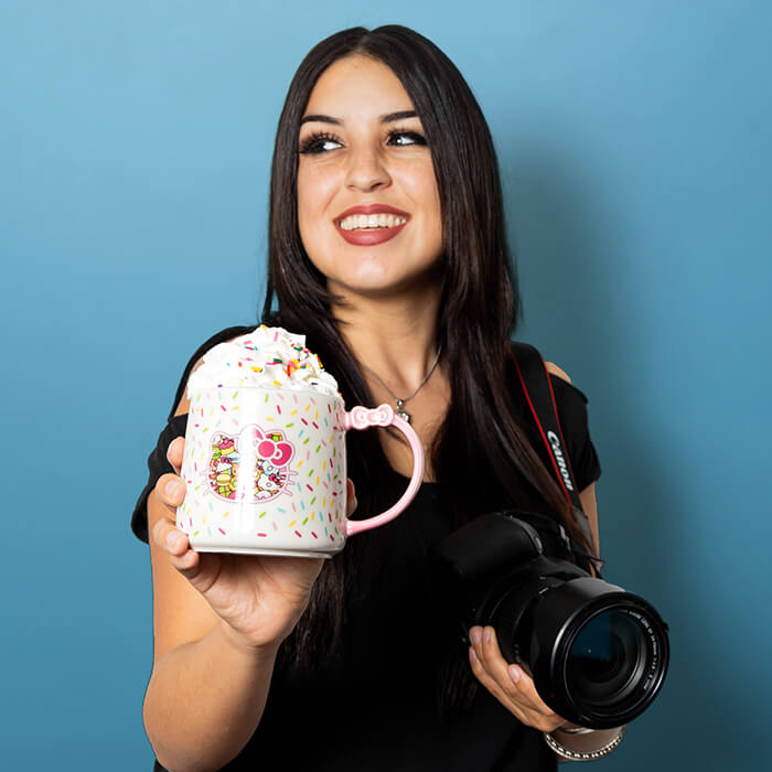 Headshot of a woman in a black shirt holding a coffee mug